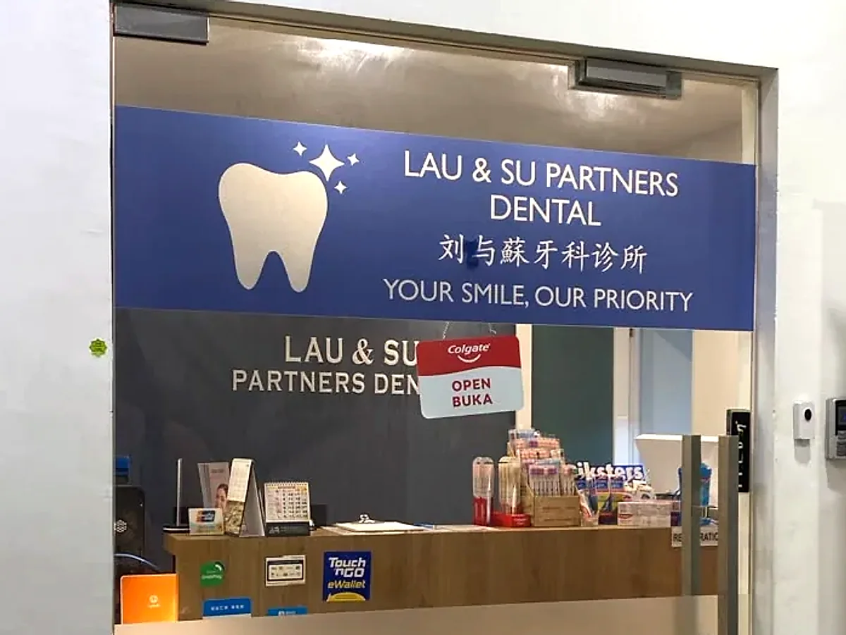 Lau & Su Partners Dental signboard and reception counter seen through the glass entrance door on the first floor at Jalil Link, Bukit Jalil